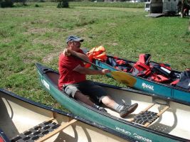 Ein Mitarbeiter des Bootsverleihs zeigt wie man das Paddel richtig hält und wie man das Kanu steuern kann