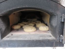 Während die Kinder zu Mittag essen, wird das Brot in den Holzofen geschoben ...