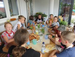Die Kinder lassen sich ihre selbst gemachte Pizza schmecken ...