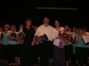Freudestrahlend stehen die drei Chorleiter am Ende des Konzertes auf der Bühne und genießen den Applaus